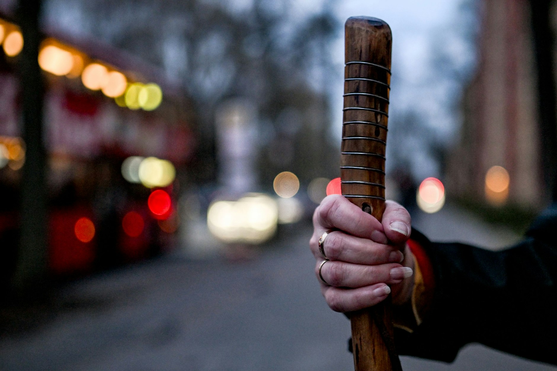 Eine Hand umfasst einen Pilgerstab bei einer Stadtpilgertour durch Berlin. 