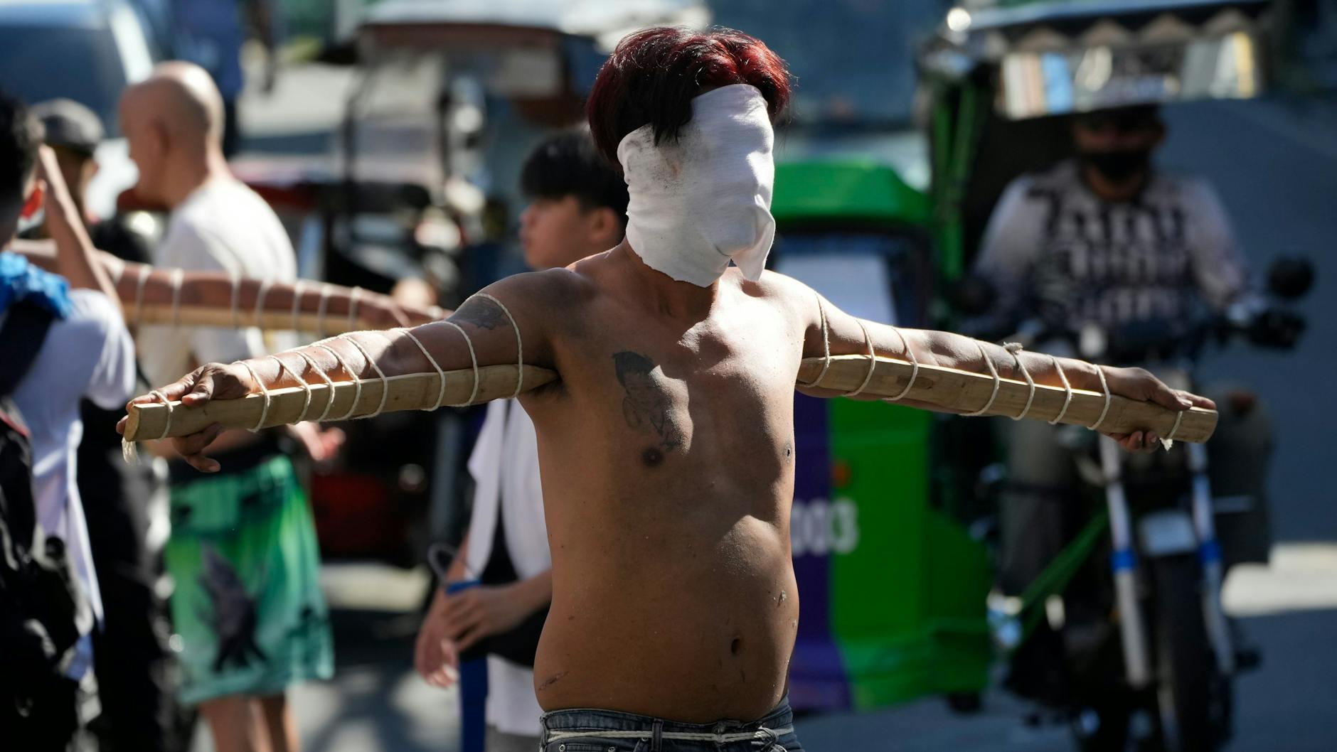 Philippinen: Ein vermummter philippinischer Büßer trägt am Gründonnerstag in der philippinischen Metropole Manila spitze Bambusstöcke unter den Armen als Teil der Rituale der Karwoche, um für Sünden zu büßen oder Gelübde für ein erhörtes Gebet zu erfüllen.