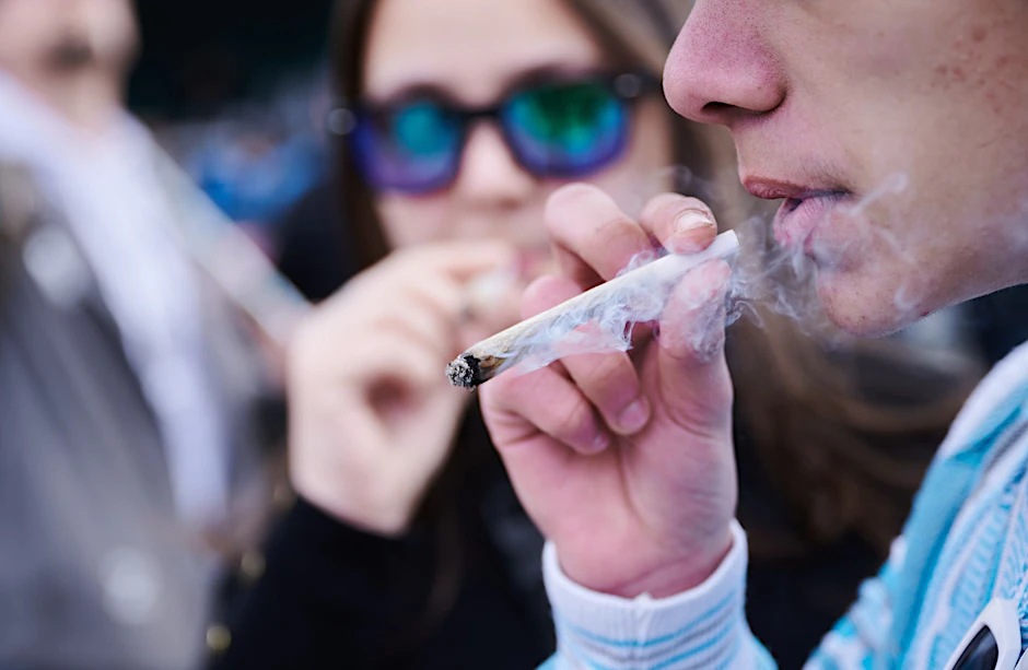 ARCHIV - Ein Demonstrant raucht einen Joint, während er an der Demonstration "Entkriminalisierung sofort - für die Freigabe von Cannabis", vor dem Brandenburger Tor teilnimmt.  