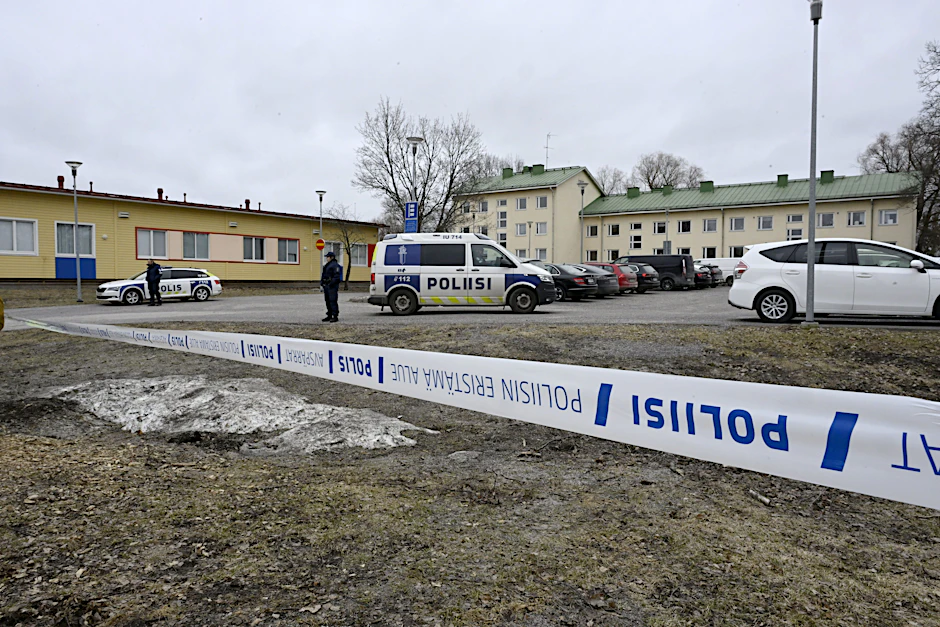 Polizeibeamte bewachen den Tatort hinter den Absperrbändern bei der Viertola-Schule.