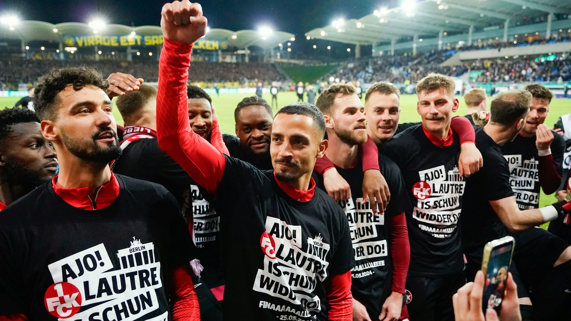 Kaiserslauterns Spieler tragen T-Shirts mit der Aufschrift "Ajo! Lautre is schun widder do!" und feiern ihren Einzug ins Finale des DFB-Pokals.
