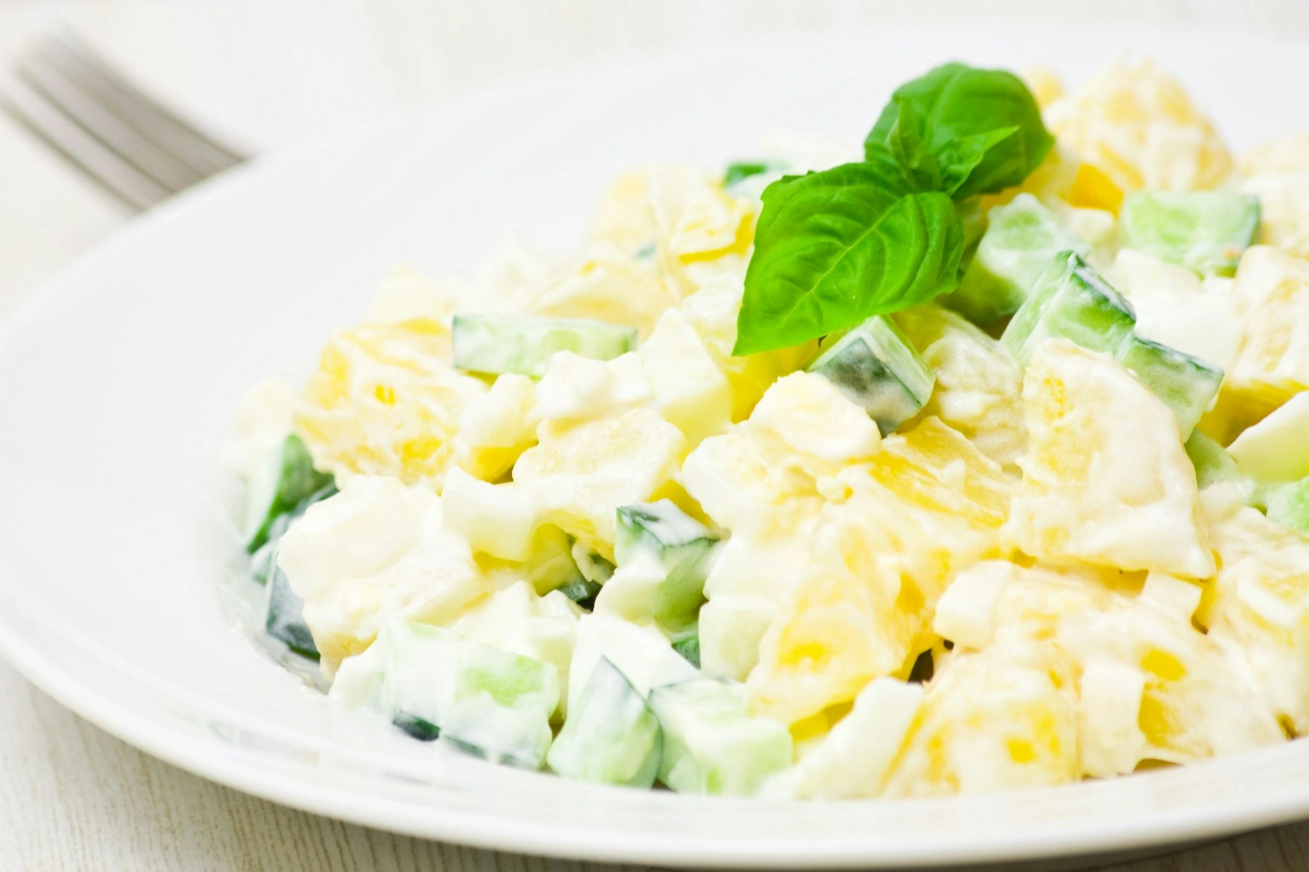 Kartoffelsalat muss nicht immer fettig und kalorienreich sein: Dieses Rezept mit Kartoffeln und Gurke setzt auf ein leichtes Joghurt-Dressing.
