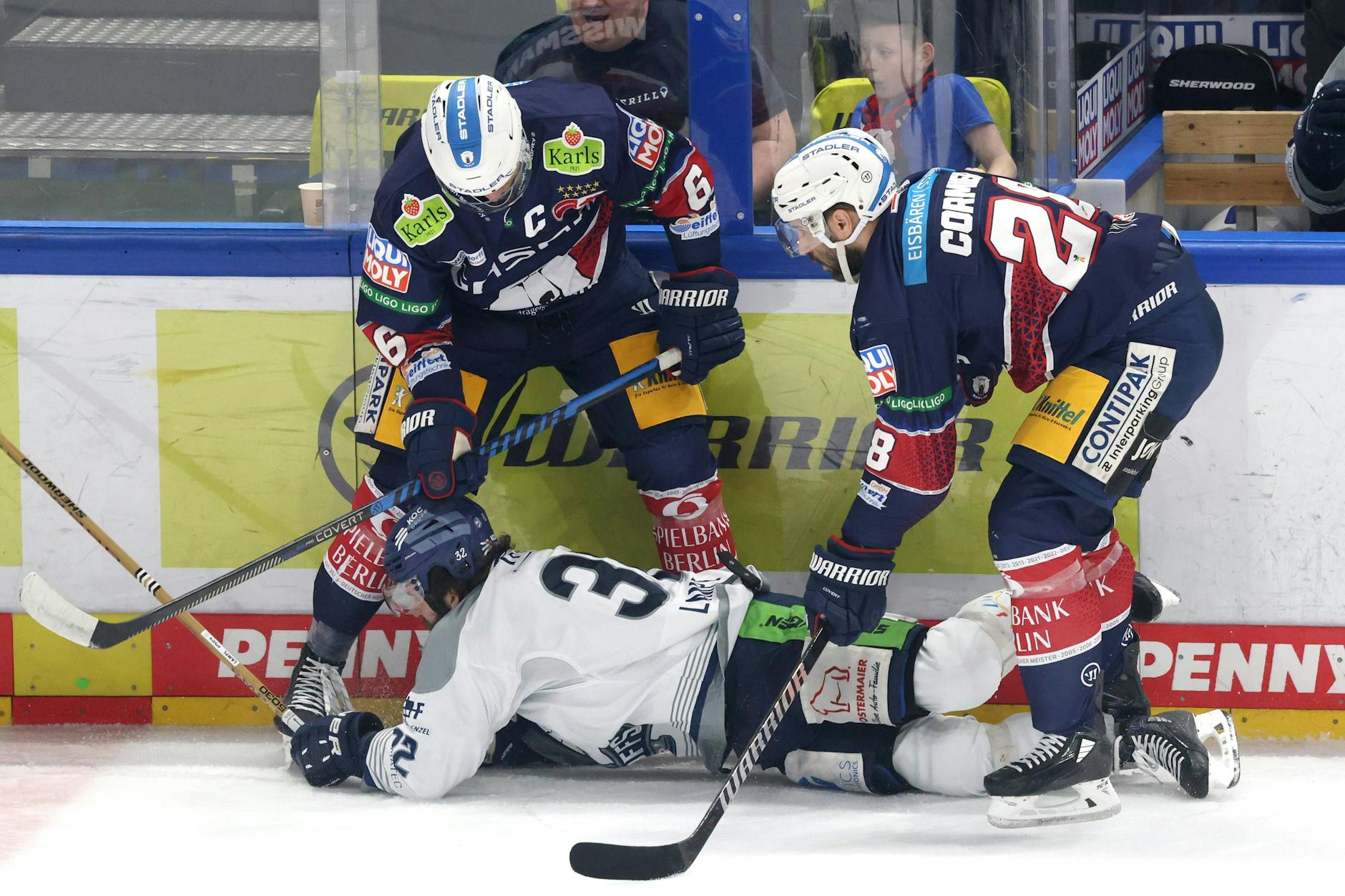 Die Eisbären Kai Wissmann (l.) und Patrice Cormier bremsen gemeinsam Straubings Cody Lampl aus.