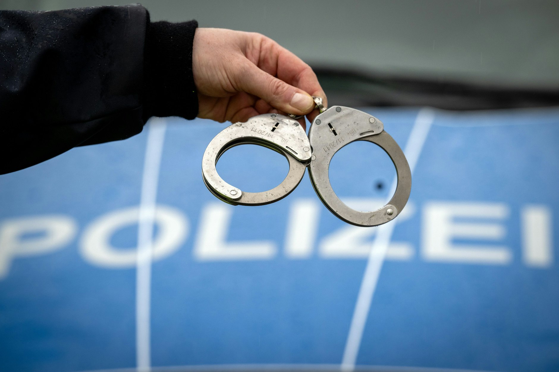 Ein Polizist hält ein Paar Handschellen.&nbsp;&nbsp;Drei Jahre nach dem Mord an einer Kosmetikerin am Berliner Kurfürstendamm ist ein Tatverdächtiger festgenommen worden. (Symbolfoto)&nbsp;