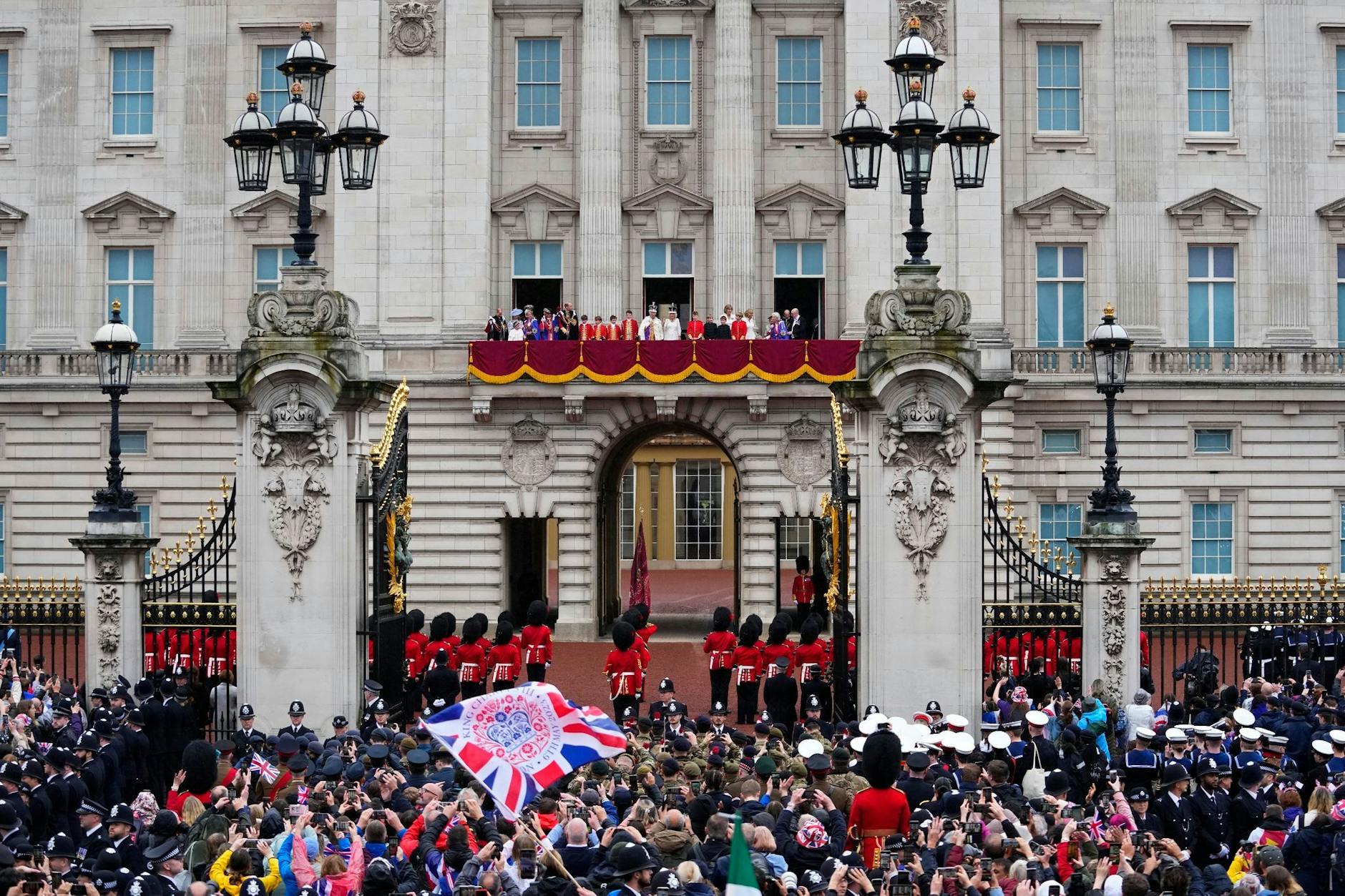 Mythenbeladener Sehnsuchtsort: Zuschauer jubeln nach der Krönung von König Charles III. und Königin Camilla vor dem Buckingham Palast in London.
