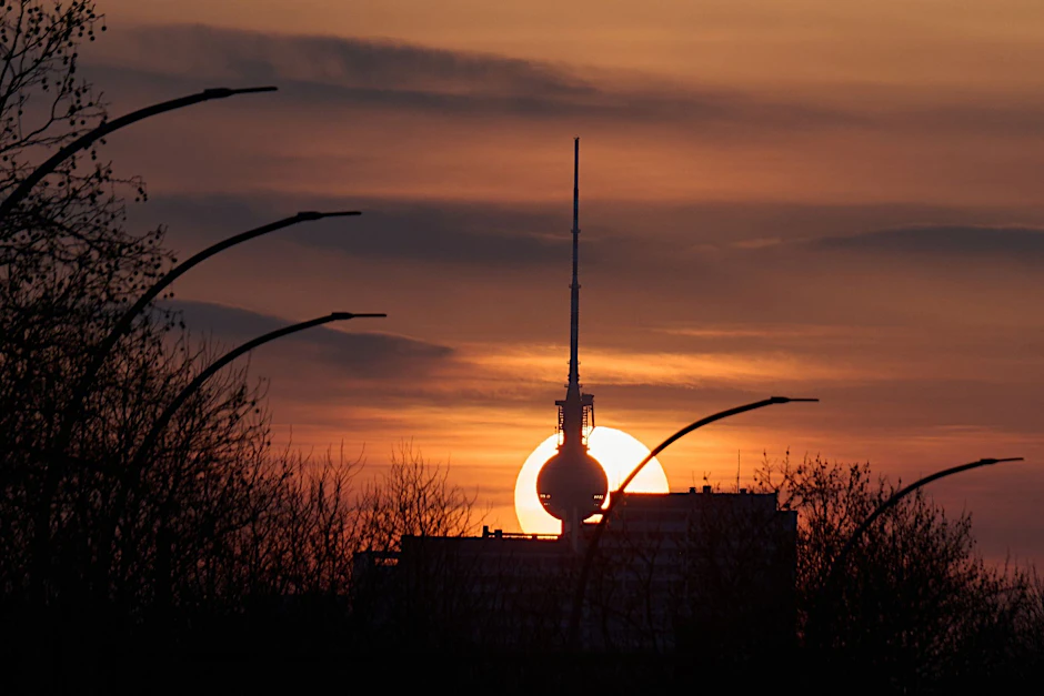 ARCHIV - Die Sonne geht hinter dem Fernsehturm unter.  