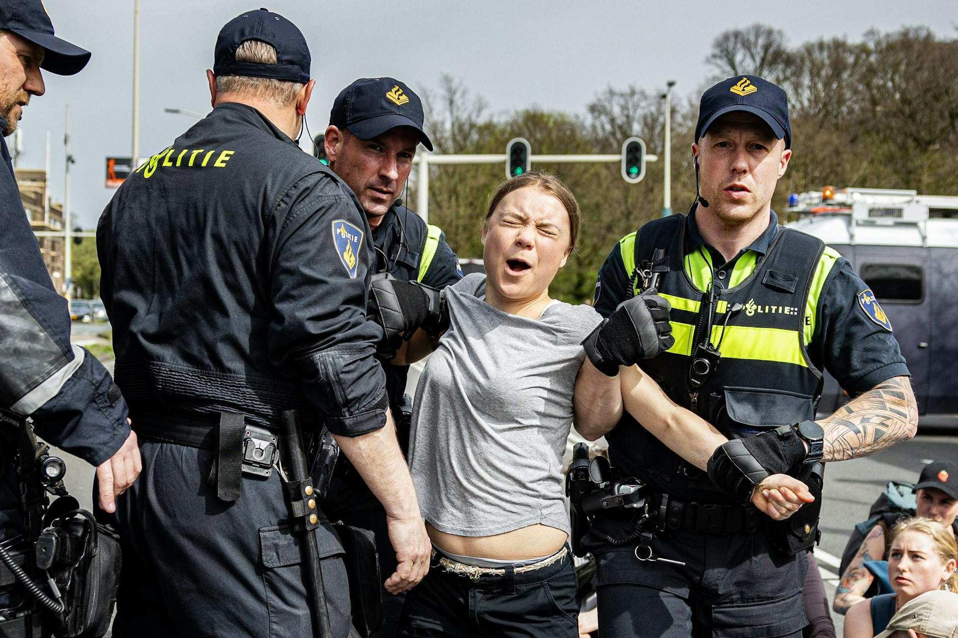 Greta Thunberg wird von Polizisten abgeführt, die eine Straßenblockade in Den Haag auflösen. 