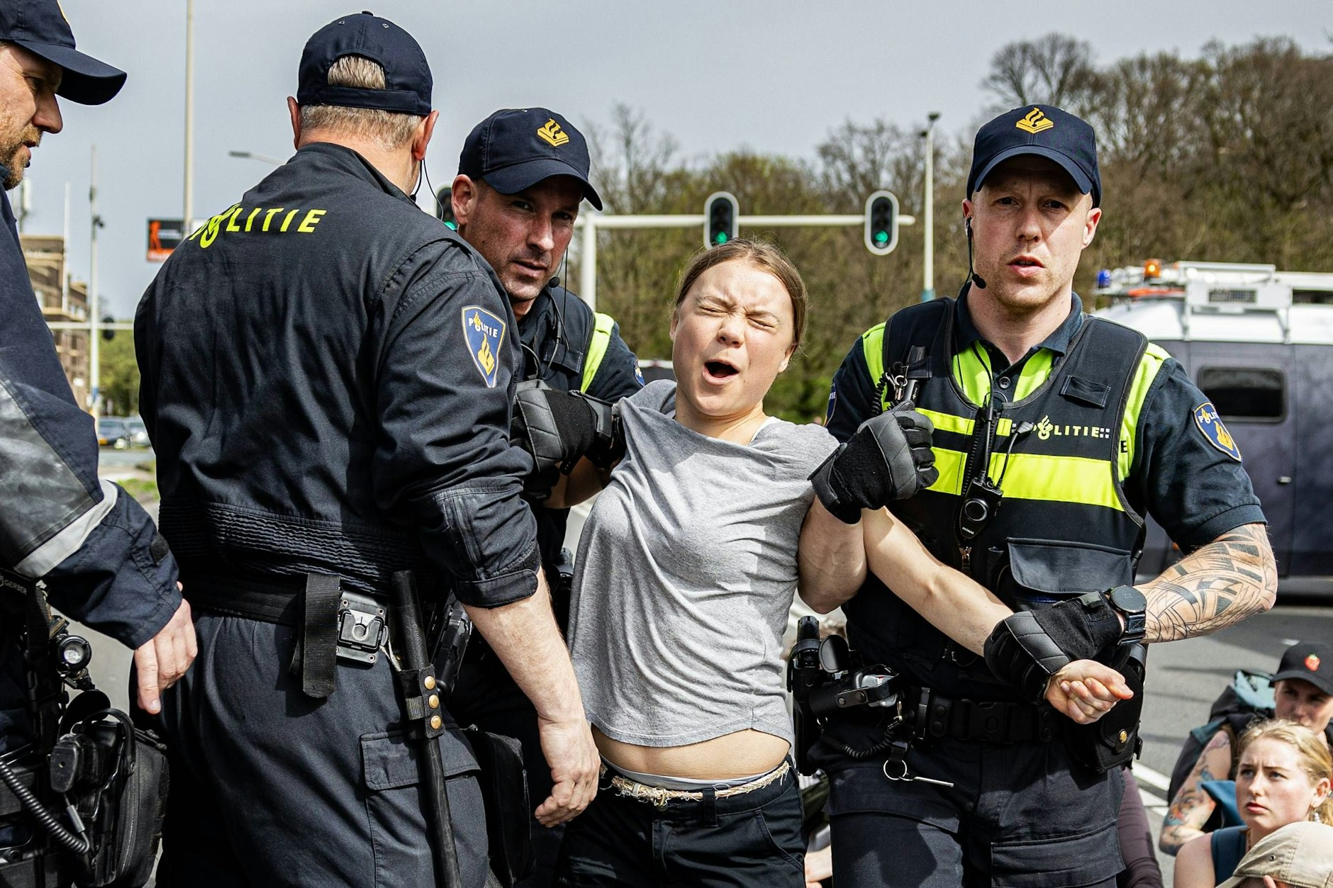 Greta Thunberg wird von Polizisten abgeführt, die eine Straßenblockade in Den Haag auflösen.&nbsp;