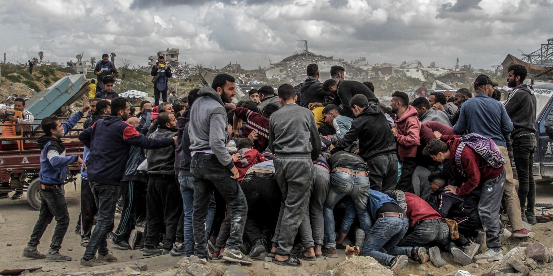 ARCHIV - Menschen drängen sich um Pakete mit humanitärer Hilfe, die über dem nördlichen Gazastreifen abgeworfen wurden. Israel hat «sofortige Schritte» zur Erhöhung humanitärer Hilfe für die Zivilbevölkerung beschlossen.