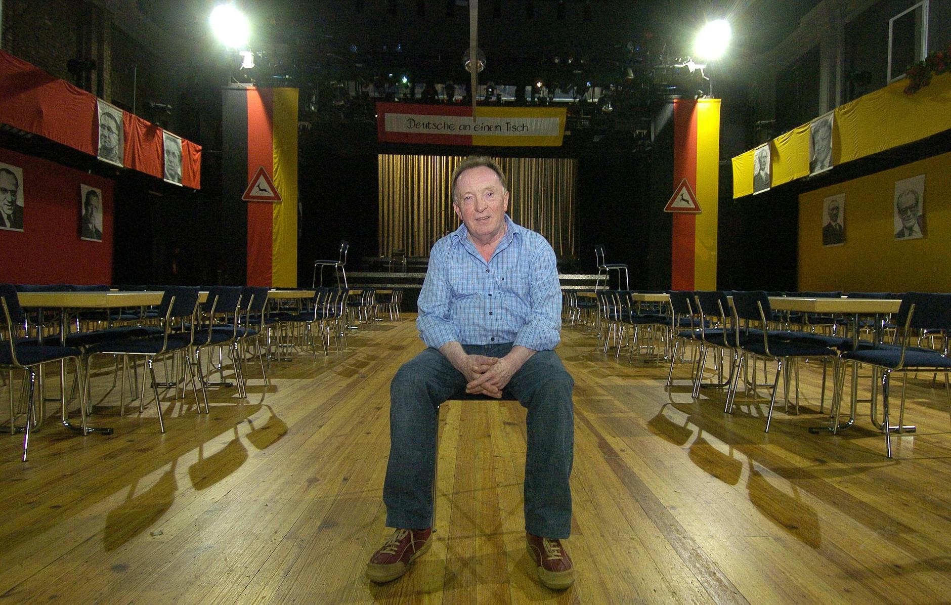 Peter Sodann, damals Intendant des Neuen Theaters in Halle, sitzt im großen Saal seines Theaters mit dem Bühnenbild seines Erfolgsstücks „Wende-Revue“.