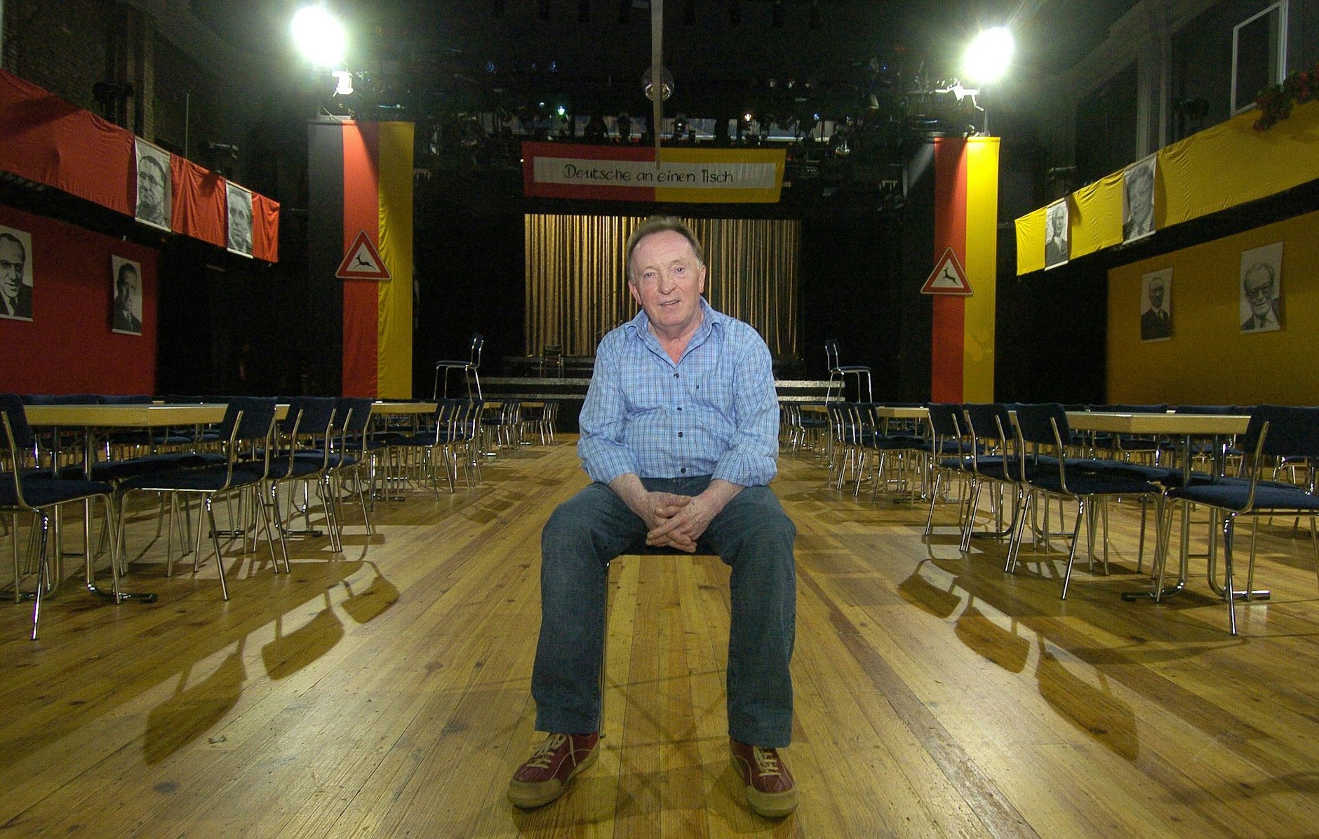 Peter Sodann, damals Intendant des Neuen Theaters in Halle, sitzt im großen Saal seines Theaters mit dem Bühnenbild seines Erfolgsstücks „Wende-Revue“.