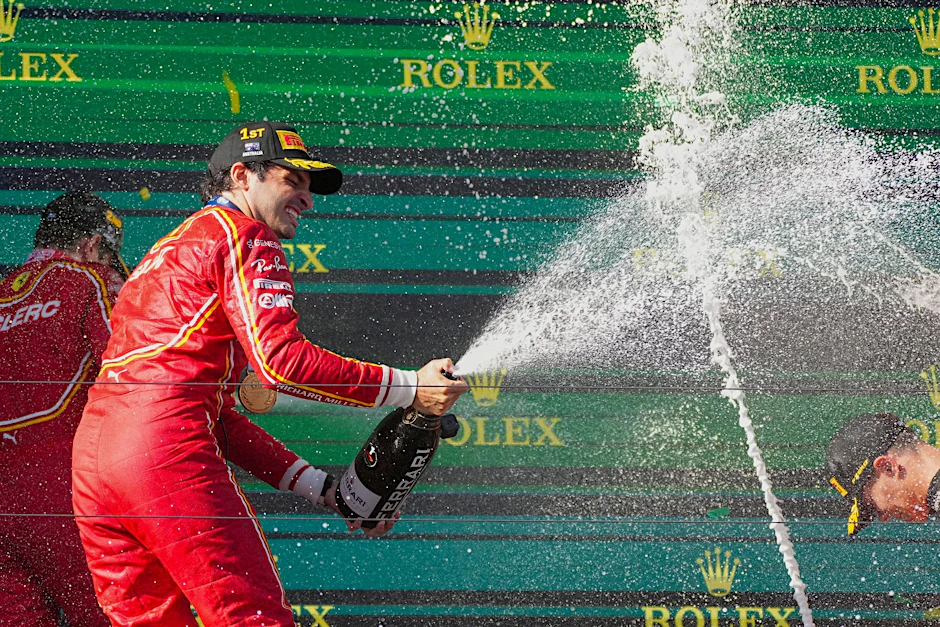 Ferrari-Pilot Carlos Sainz feiert mit Champagner seinen Sieg.  