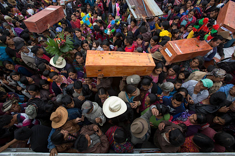 ARCHIV - Guatemala: Menschen tragen in Santa Avelina Särge mit den Überresten von indigenen Bürgerkriegsopfern. Der Ex-Militärchef in Guatemala steht erneut vor Gericht.  