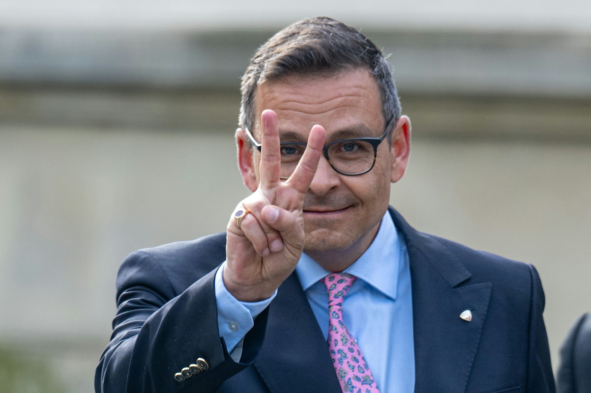 Der österreichische Politiker Gerald Grosz zeigt vor dem Amtsgerichtsgebäude das Victory-Zeichen.