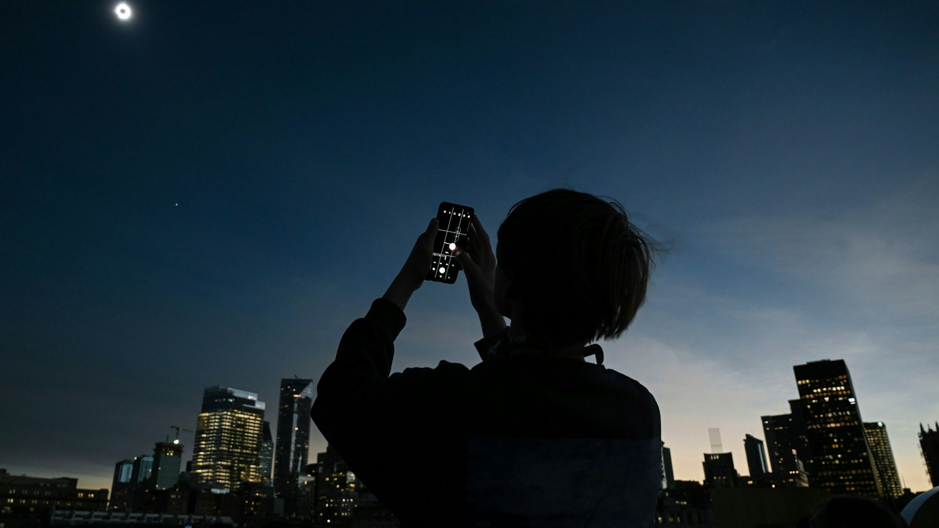 Eine Person im kanadischen Montreal fotografiert die Sonne während der totalen Sonnenfinsternis.