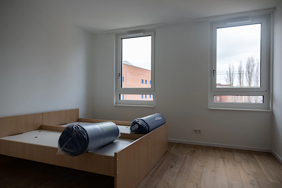 ARCHIV - Blick in einen Raum mit zwei Betten in einer Wohnung der Mobilen Unterkunft für Geflüchtete.  