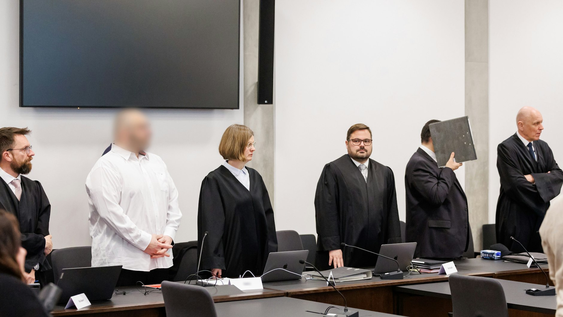 Die beiden wegen Mordes angeklagten Männer (2.v.l. und 2.v.r.) stehen zu Prozessbeginn im Sitzungssaal im Landgericht Nürnberg-Fürth zwischen ihren Anwälten.