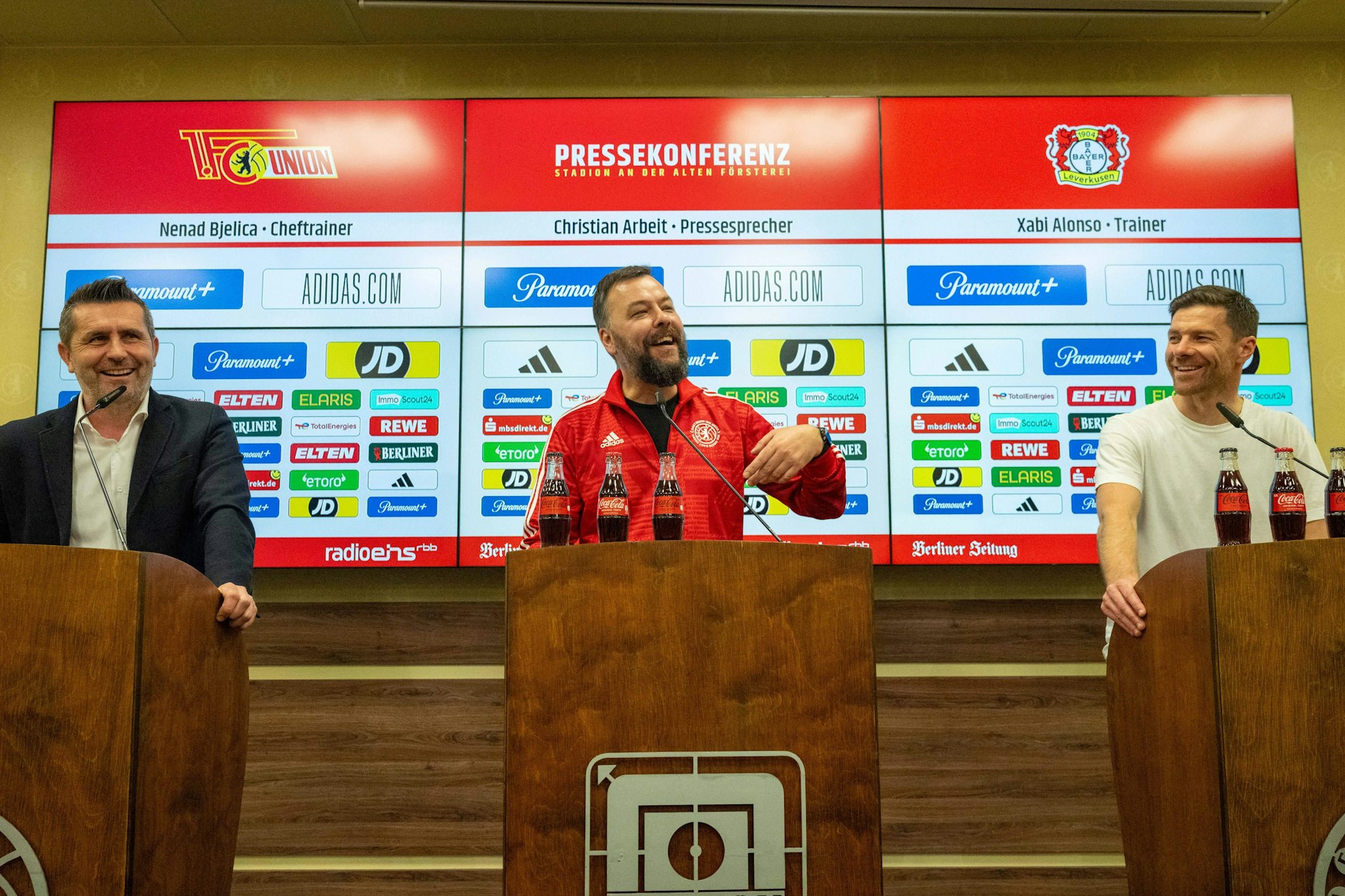 Gute Laune trotz Niederlage: Union-Trainer Nenad Bjelica bringt Pressesprecher Christian Arbeit und Bayer-Coach Xabi Alonso zum Lachen.