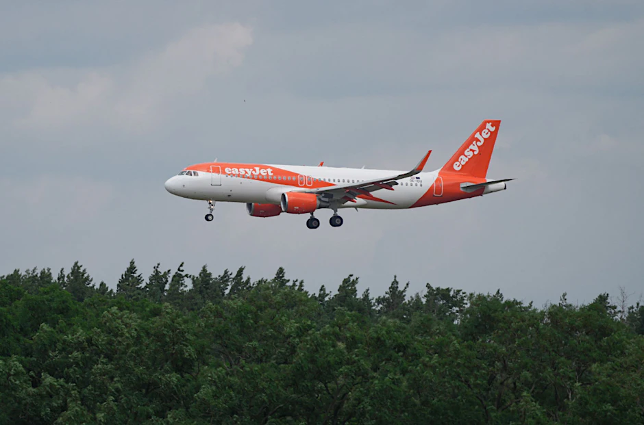 ARCHIV - Ein Airbus A 320-214 landet hinter Bäumen auf dem BER-Flughafen.  
