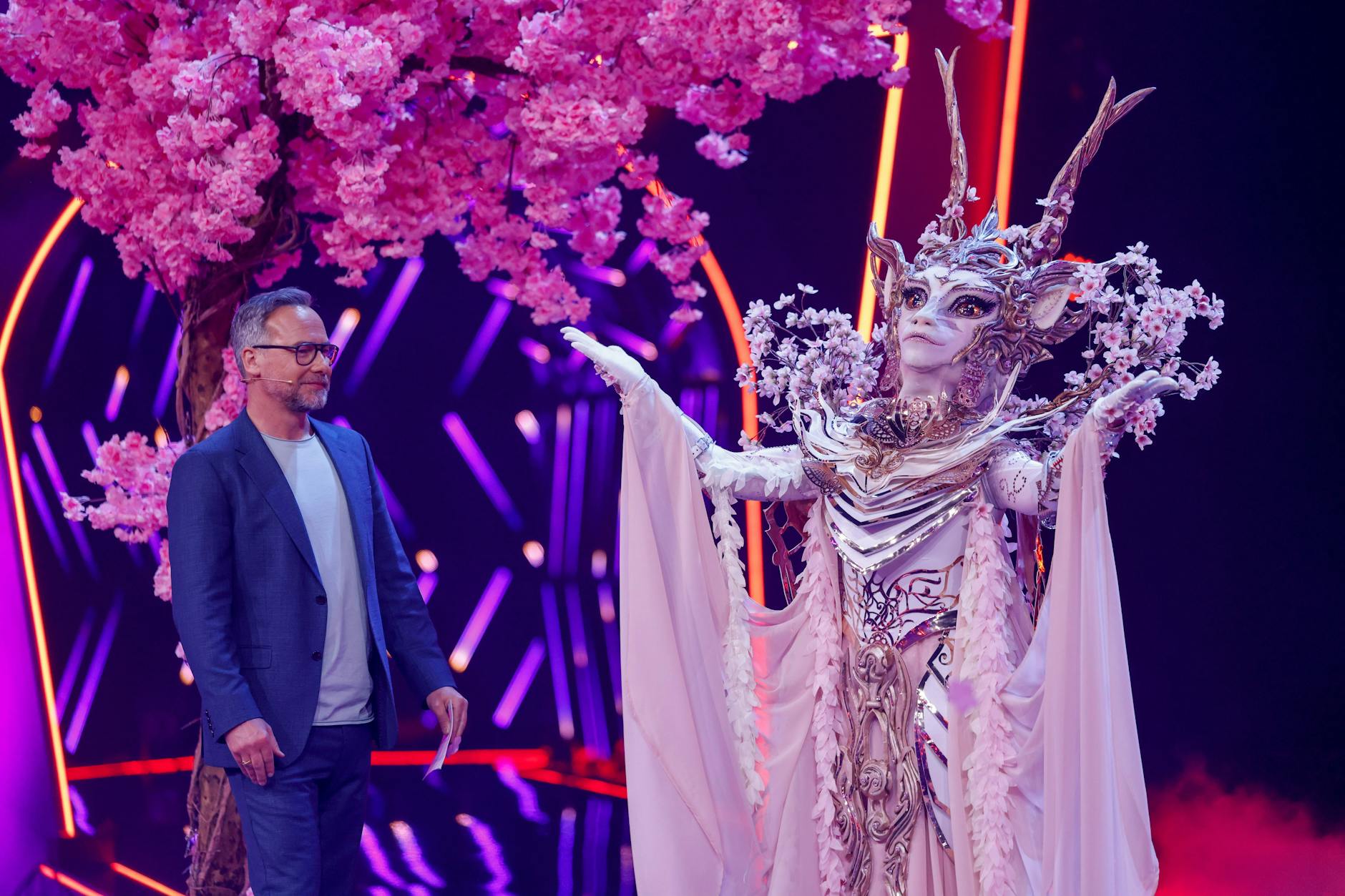 Elgonia mit Moderator Matthias Opdenhövel auf der Bühne von „The Masked Singer“.