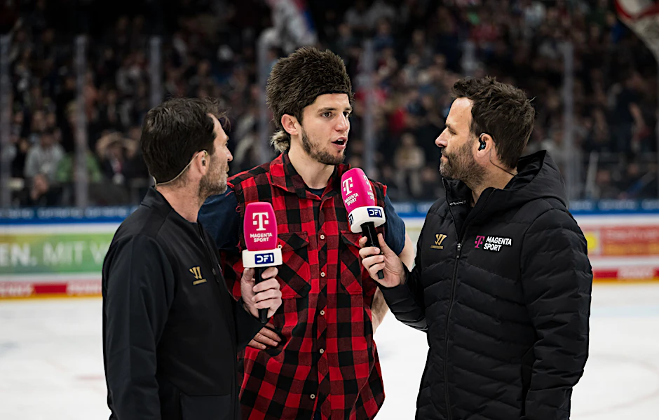 Ein ungewöhnliches Outfit, welches Frederik Tiffels (Mitte) von den Eisbären Berlin im Interview mit Experte Sven Felski (l.) und Moderator Holger Speckhahn nach dem Spiel gegen die Straubing Tigers trug.