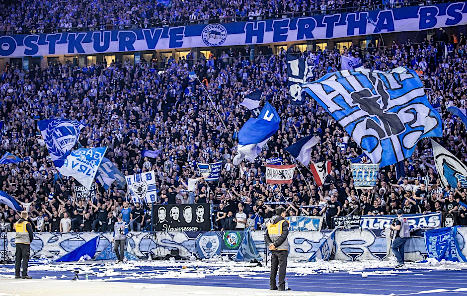 ARCHIV - Fans von Hertha BSC feuern ihr Team aus der Ostkurve mit Fahnen an.  