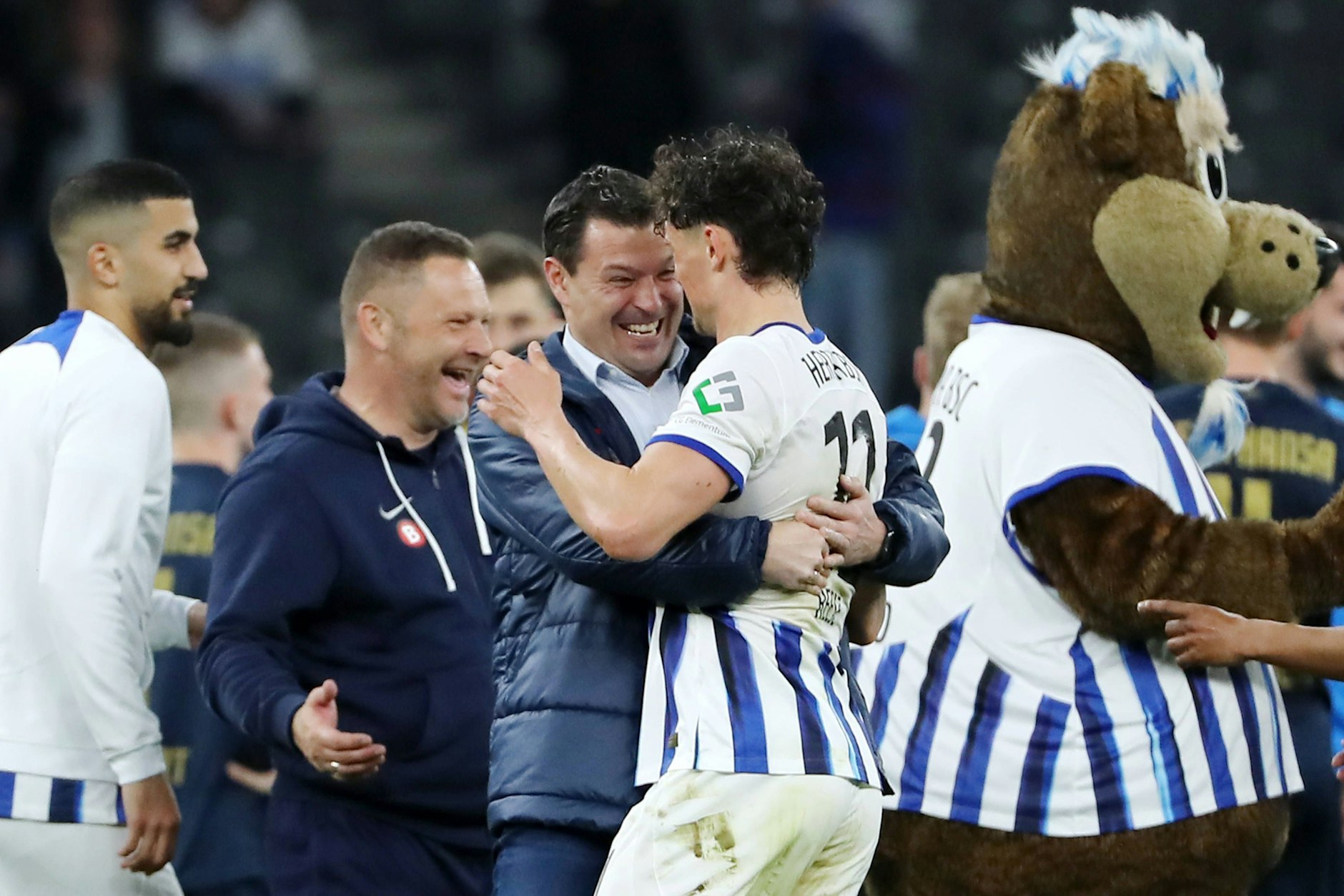 Hertha-Trainer Pal Dardai, Sportdirektor Benjamin Weber, Stürmer Fabian Reese und Maskottchen Herthinho feiern den 4:0-Sieg gegen Hansa Rostock. 
