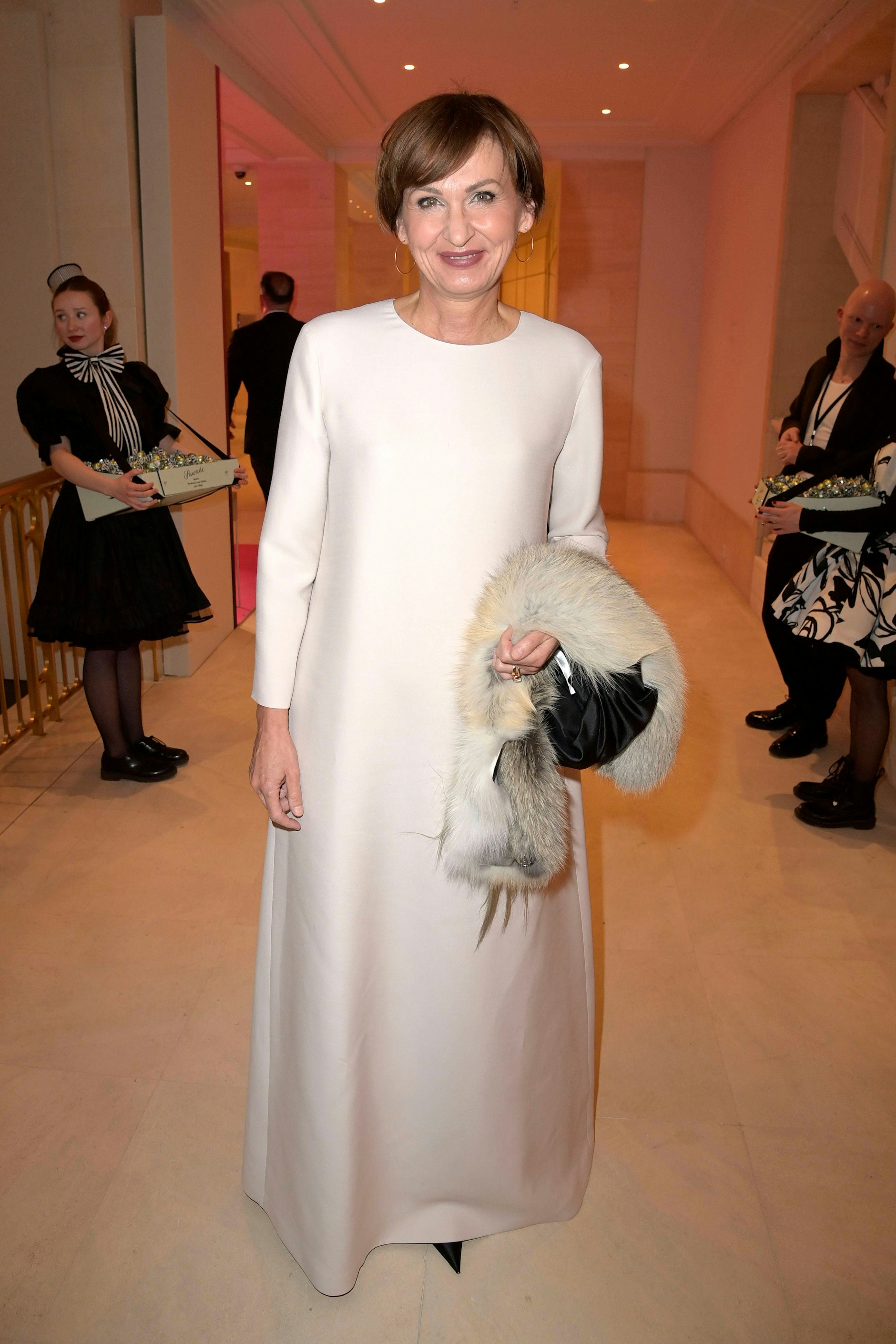 <strong>TOP</strong>: Nanu, was ist denn das für ein Fiffi, den <strong>Bettina Stark-Watzinger</strong> da zum Presseball mitbrachte? Echtpelz – kann das sein? Wir wissen es nicht, finden den Auftritt der Bundesministerin für Bildung und Forschung aber so oder so grandios: Das cremeweiße, locker geschnittene Abendkleid mit Rundhalsausschnitt und langen Ärmeln begeistert mit zurückhaltender Noblesse; schön auch die unaufgeregte Bobfrisur und der bräunliche Lippenstift, der der Politikerin ungemein gut steht. Bitte weiter so!