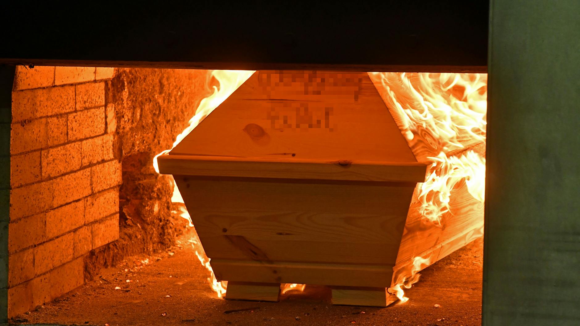Ein Sarg wird in einem Krematorium verbrannt.
