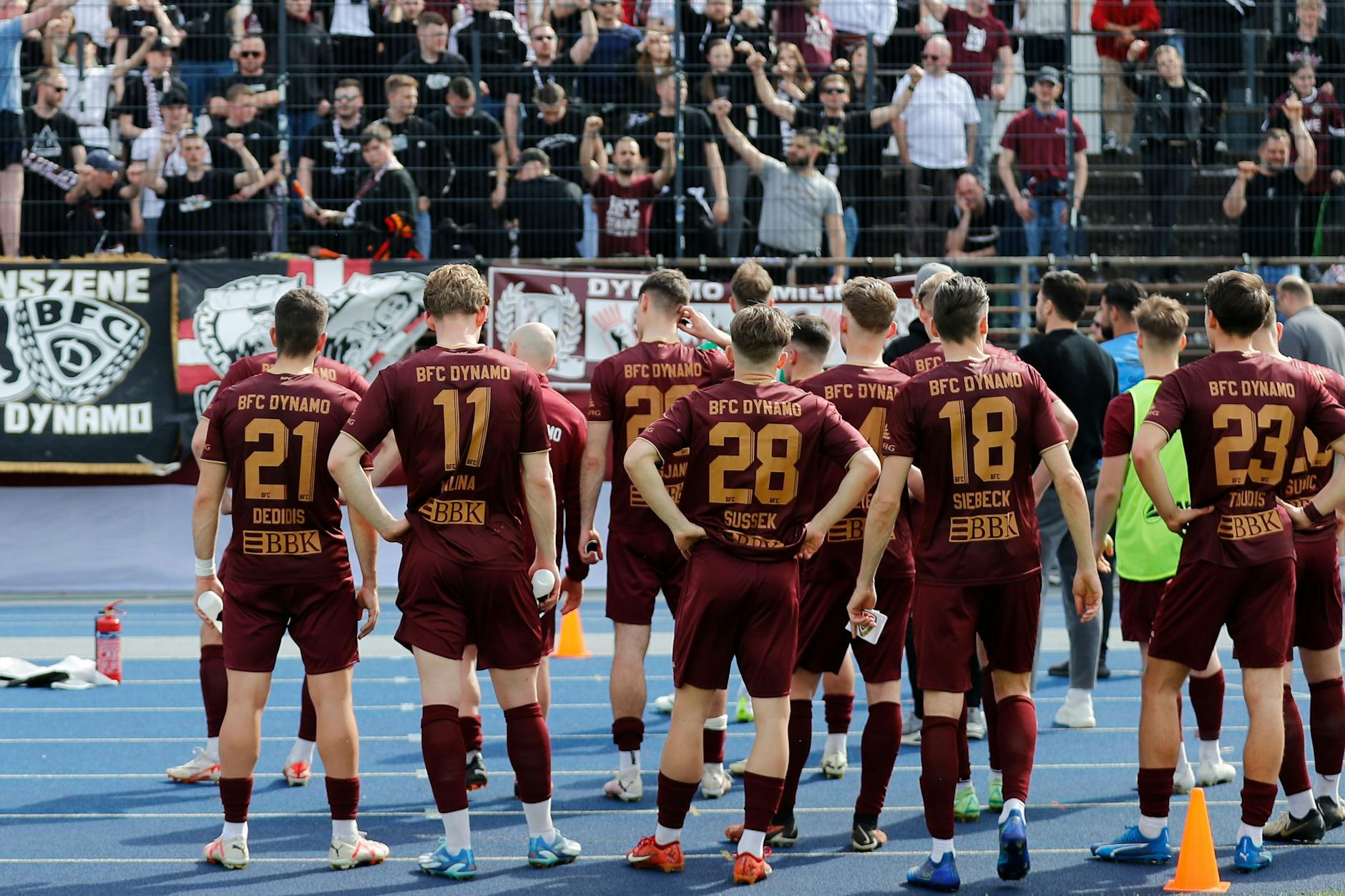 Die Spieler des BFC Dynamo sind nach dem 1:3 bei Viktoria bedient, die weinrot-weißen Fans versuchen, sie wieder aufzurichten.
