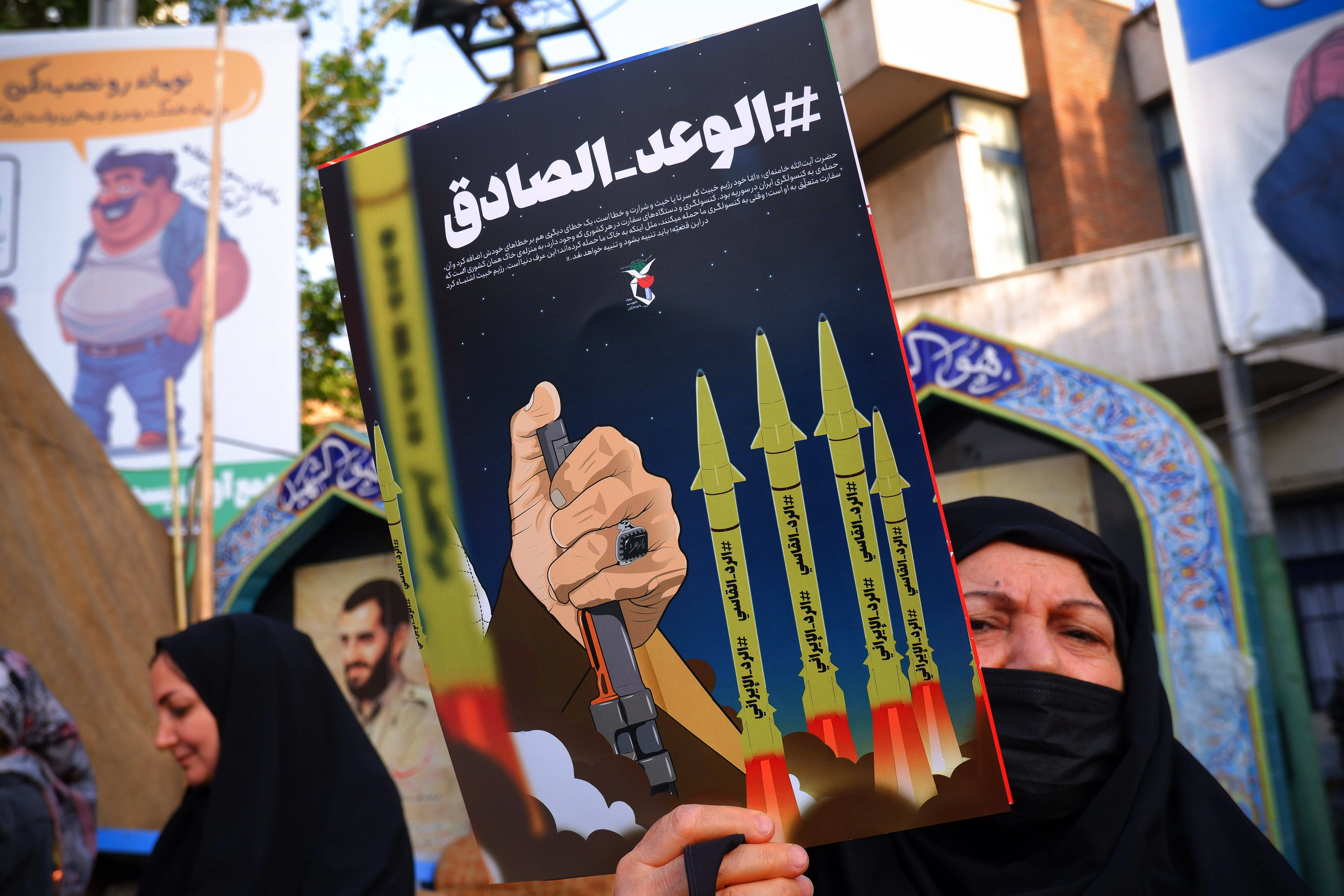 Eine iranische Regierungsbefürworterin hält ein Anti-Israel-Plakat in der Palästina-Straße im Zentrum von Teheran.