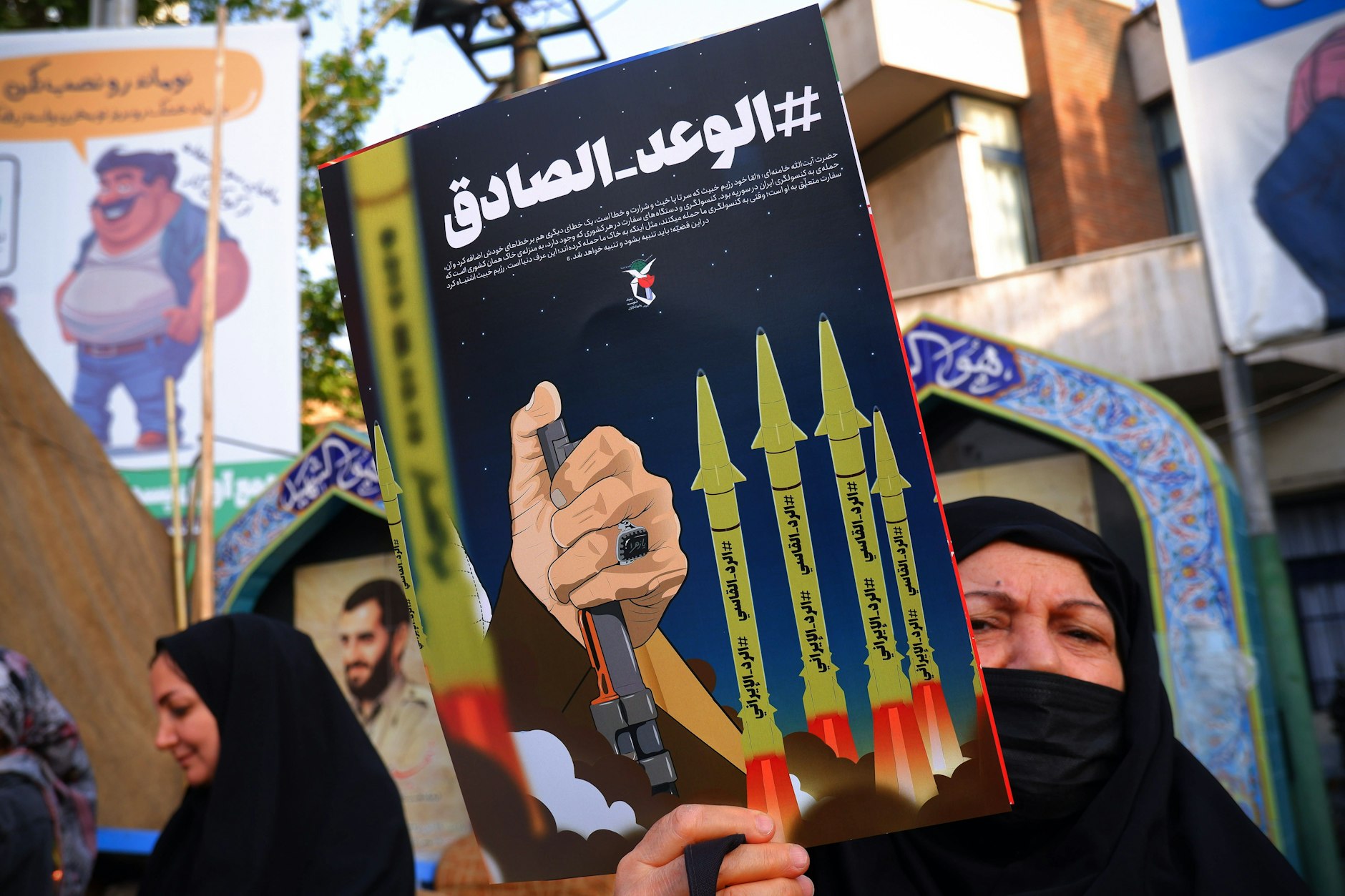 Eine iranische Regierungsbefürworterin hält ein Anti-Israel-Plakat in der Palästina-Straße im Zentrum von Teheran.