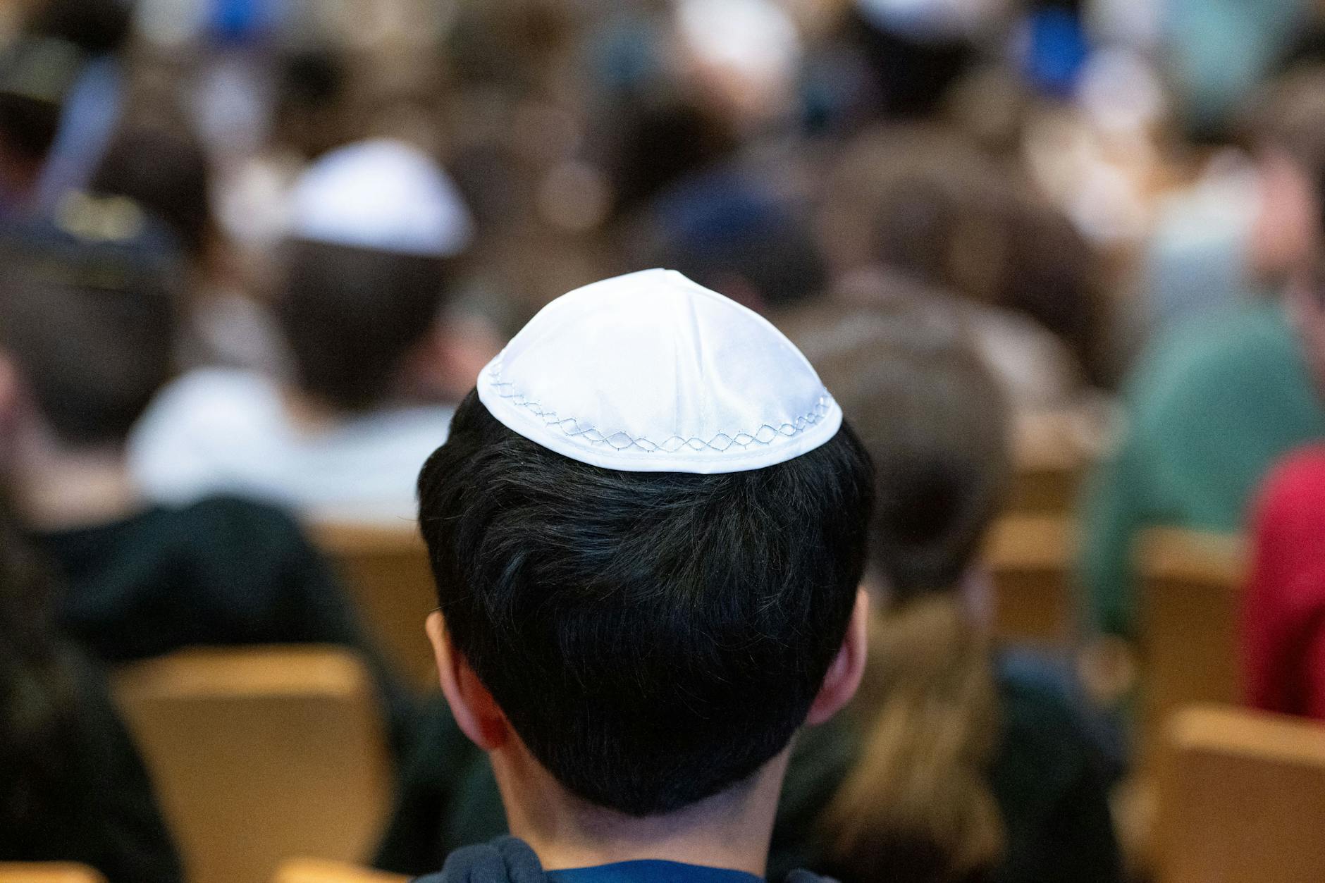 Ein Schüler mit einer Kippa sitzt in der Aula der Heinz-Galinski-Schule in Berlin. Dort werden 20 israelische, durch die Angriffe der Hamas traumatisierte Kinder und Jugendliche empfangen.