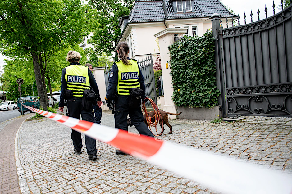 Polizistinnen suchen vor der Villa mit einem Hund nach Spuren.&nbsp;