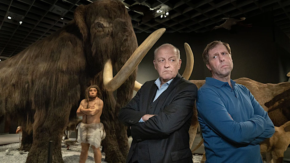 HANDOUT - Privatdetektiv Wilsberg (Leonard Lansink) Rücken an Rücken mit Ekki (Oliver Korittke) in einem Raum eines Naturkundemuseums.  