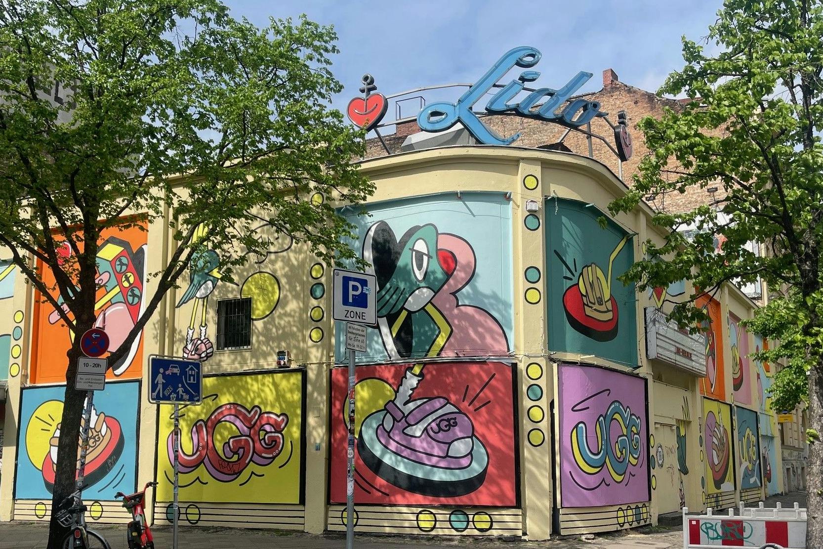 Was ist hier los? Treter statt Mucke. Auf der Fassade der Berliner Konzertlocation Lido macht die Schuhfirma UGG Werbung für die neue Kollektion, eher so Sandalen. 
