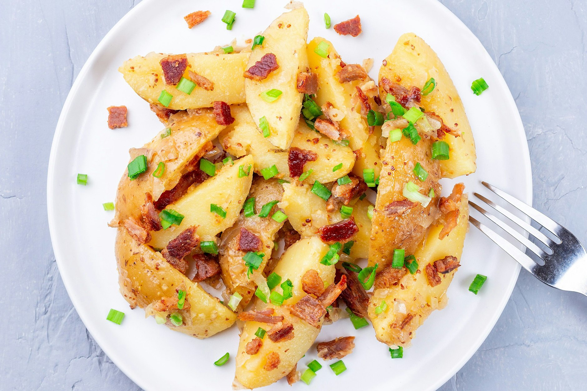 Das beste Rezept zum Grillen: Dieser köstliche und würzige Kartoffelsalat mit Bacon und Frühlingszwiebeln ist ruckzuck fertig - und braucht keine fettige Soße!