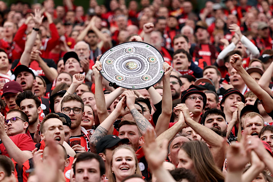 Fußball: Ein Leverkusener Fan hält während des Spiels eine Nachbildung der Meisterschale in den Händen. Bayer Leverkusen gewinnt die Deutsche Meisterschaft.  