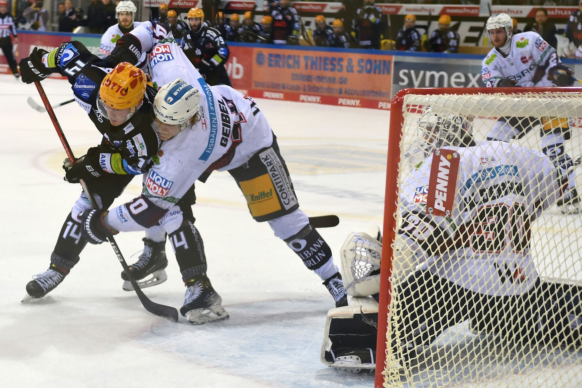 Bremerhavens Ross Mauermann (l.) kämpft gegen Eisbär Korbinian Geibel vor Torwart Jake Hildebrand (r.) um den Puck. 