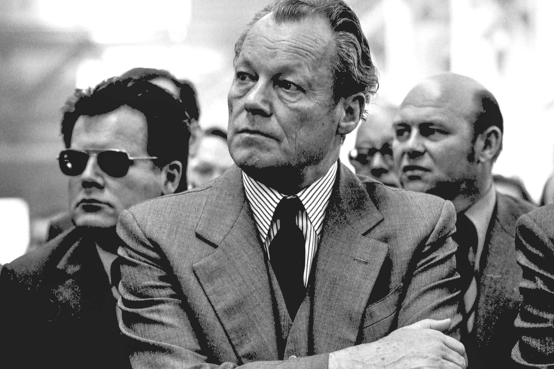 In den Rücken gefallen: Bundeskanzler Willy Brandt besucht am 8. April 1974 eine Veranstaltung in Helmstedt. Zu dieser Zeit weiß er, dass sein persönlicher Referent Günter Guillaume, hier mit Sonnenbrille, der Spionage für die DDR verdächtigt wird.