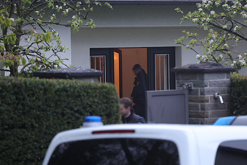 Solingen: Polizeibeamte stehen an einem Haus, das durchsucht wird. Bei einer Razzia gegen eine Schleuserbande in acht Bundesländern wurden zehn Verdächtige verhaftet.