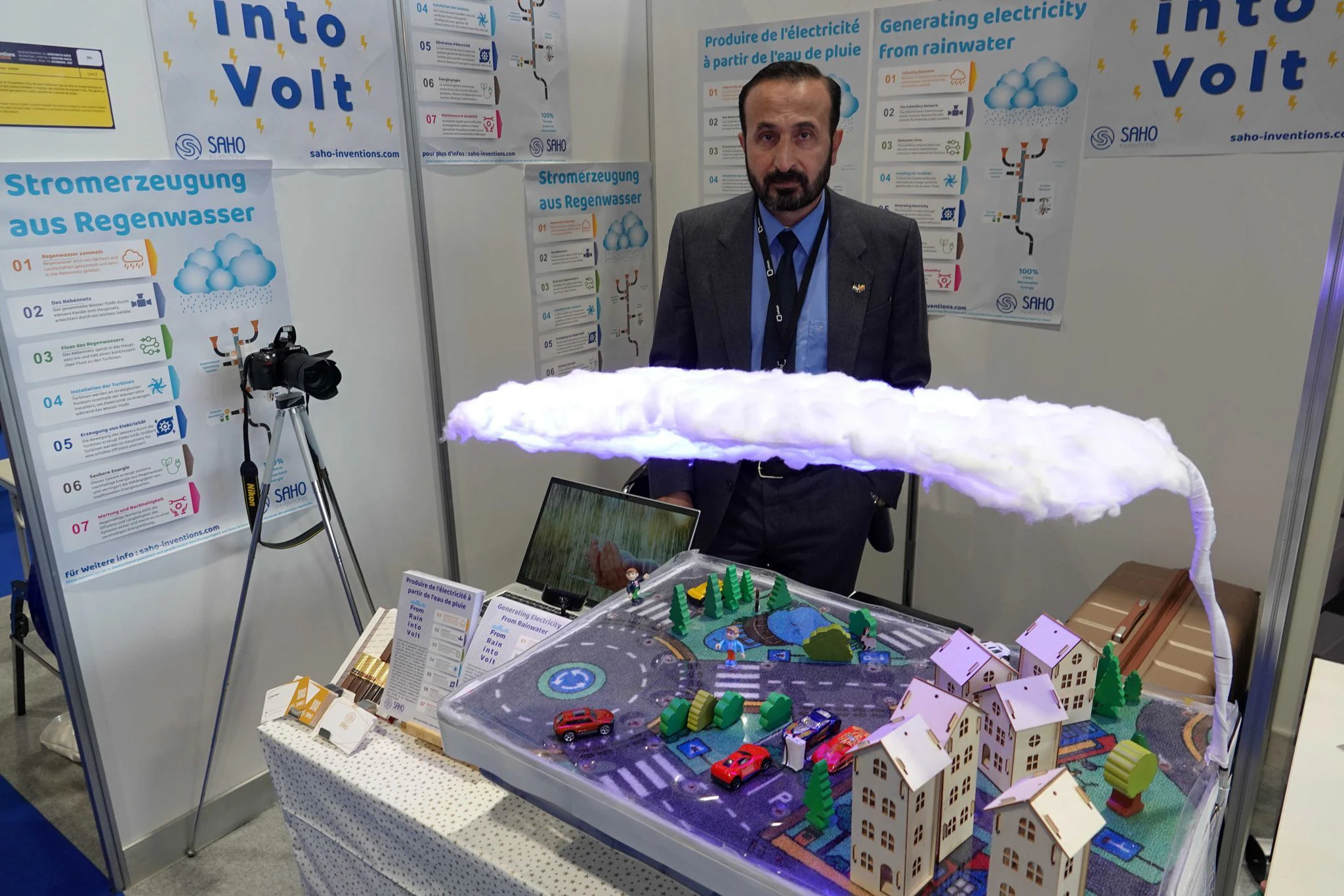 Khaled Al-Saho steht hinter seinem Modell, das die Produktion von Energie aus Regenwasser erklärt.  