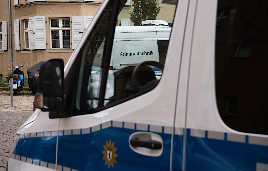 ARCHIV - Fahrzeuge der Kriminaltechnik und Polizei stehen vor einer Häuserzeile in Berlin-Köpenick.  