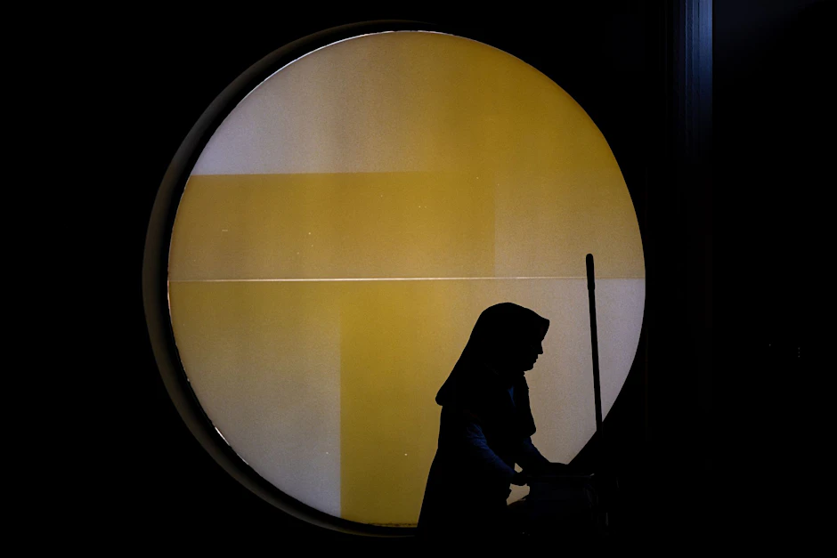 Eine Reinigungskraft steht vor einem runden Fenster in der Berliner Philharmonie.&nbsp;
