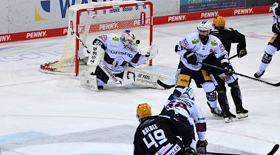 Bremerhavens Lukas Kälble (l) erzielt das Tor zum 1:2 gegen Berlins Torwart Torwart Jake Hildebrand.  