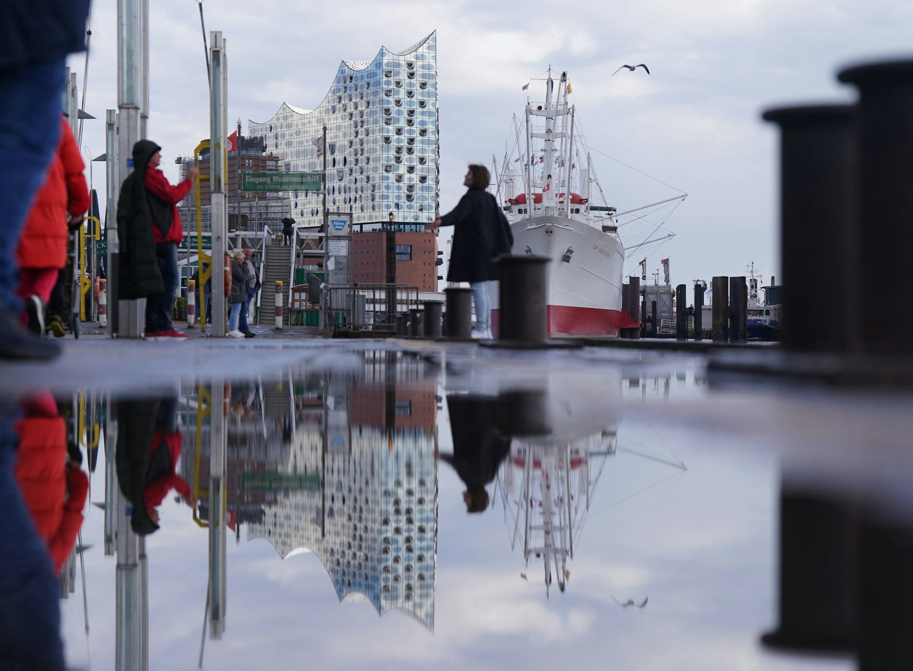 Die Elbphilharmonie spiegelt sich an den Landungsbrücken im Hamburger Hafen.