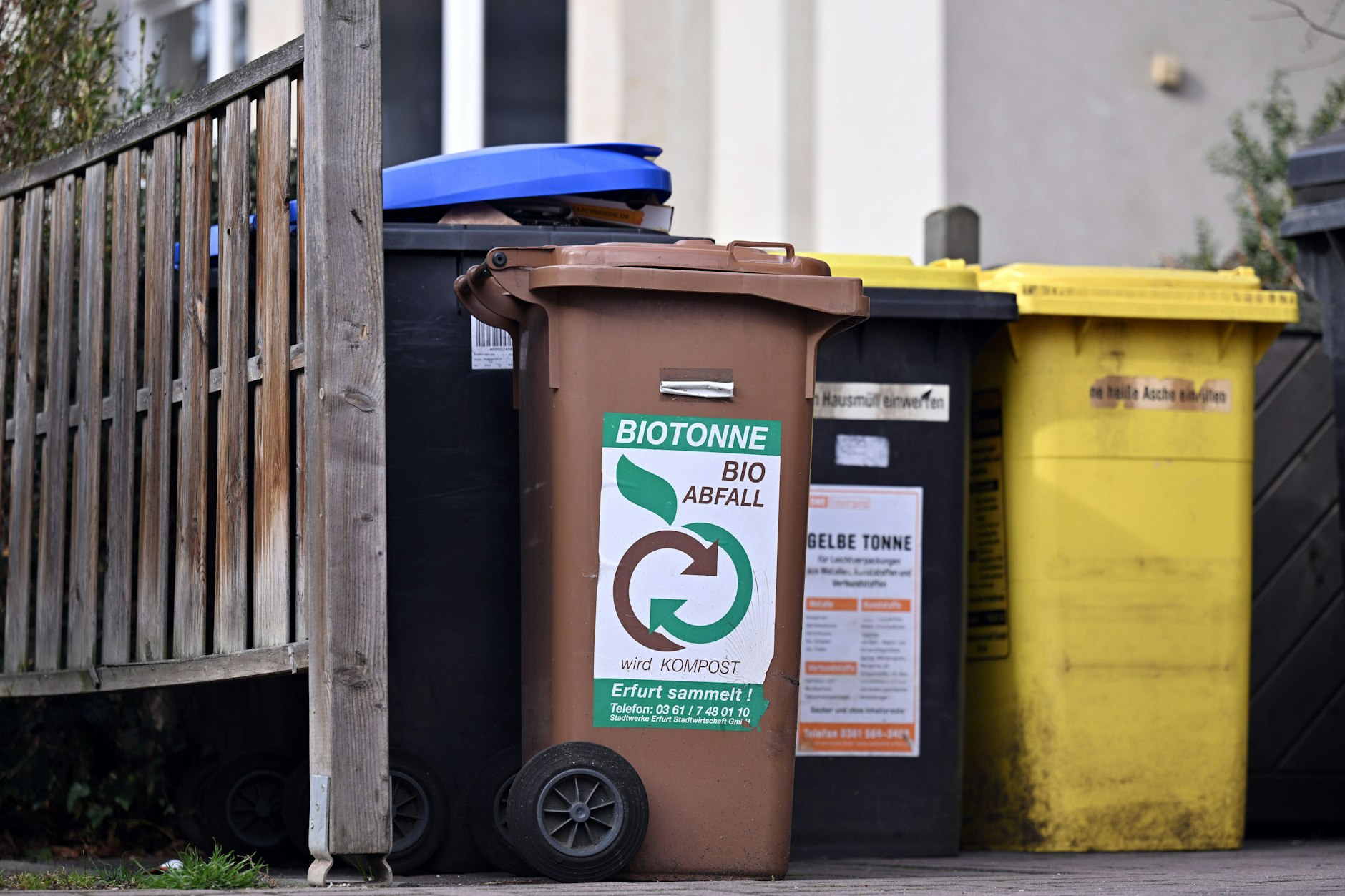Eine Biotonne steht mit Tonnen für Wertstoffe, Papier und Restmüll vor einem Wohnhaus in Erfurt.&nbsp;&nbsp;