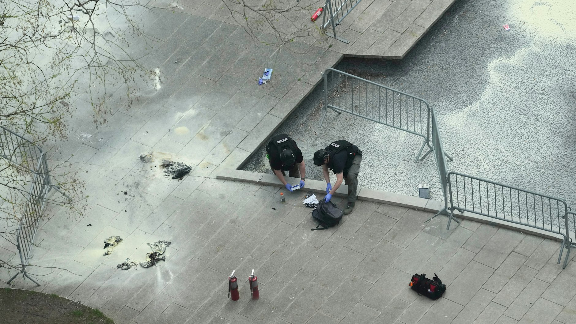 New Yorker Polizeibeamte inspizieren einen Rucksack an der Stelle im Collect Pond Park, an der sich ein Mann vor dem Strafgericht in Manhattan angezündet hat.&nbsp;