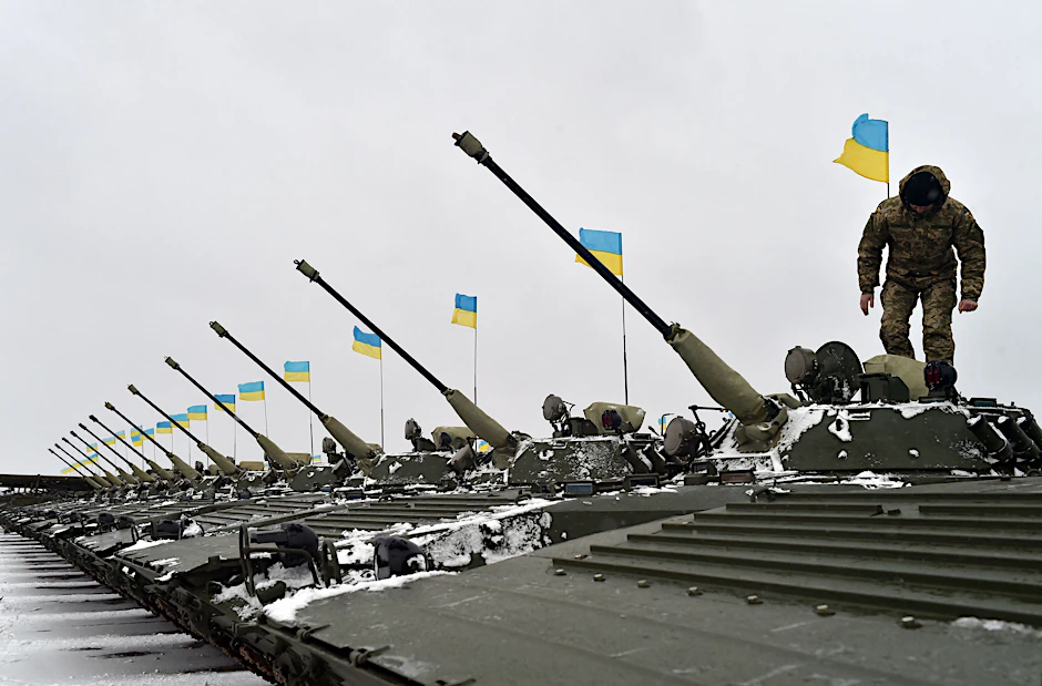 Ein ukrainischer Soldat besteigt ein gepanzertes Fahrzeug während einer Übergabezeremonie von militärischer Ausrüstung an die ukrainischen Streitkräfte.