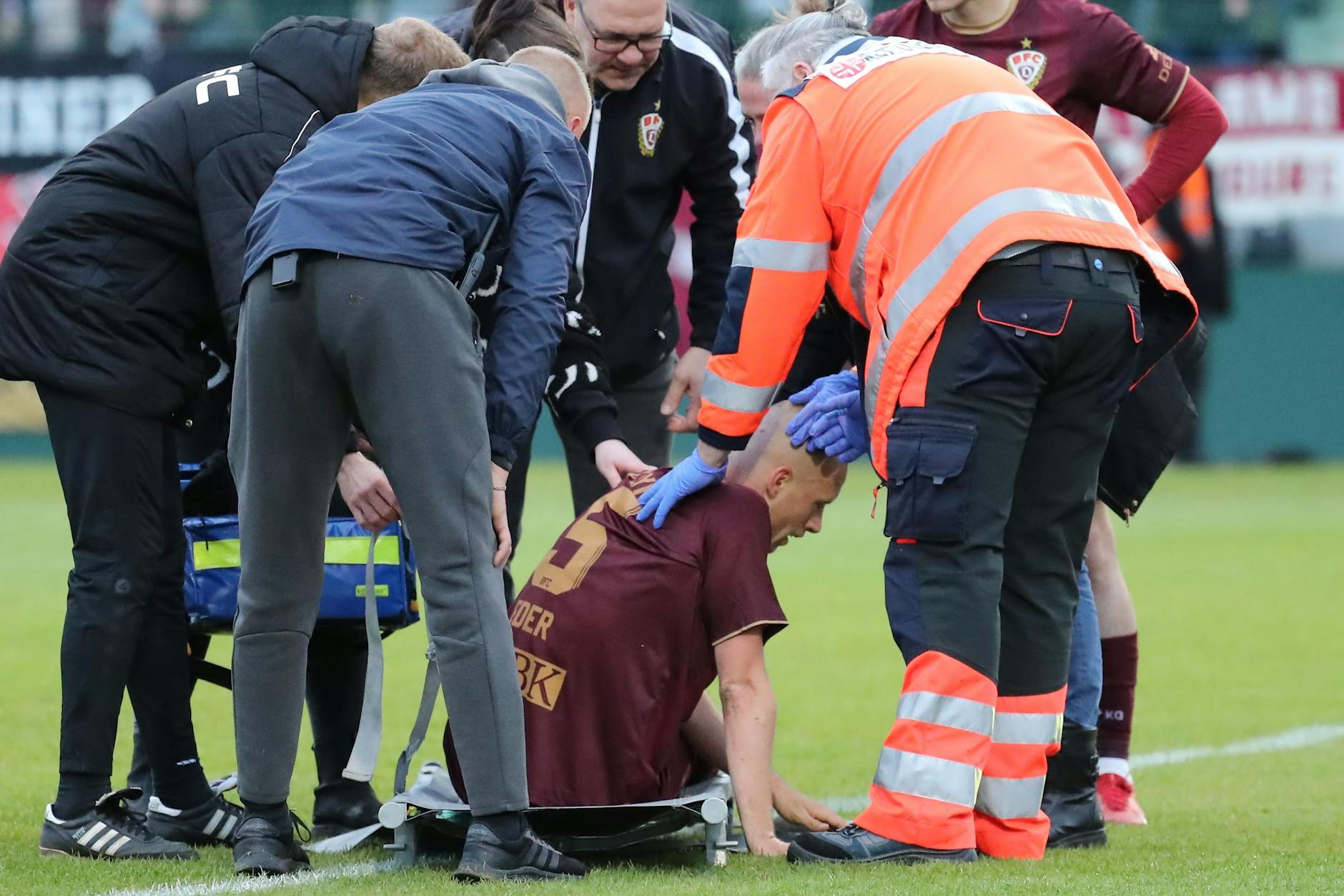 Steffen Eder vom BFC Dynamo sitzt nach seinem Zusammenprall im Spiel gegen Rot-Weiß Erfurt immer noch total benommen auf der Trage.